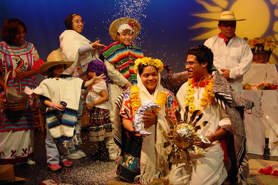 A group of adults and children wearing native Mexican wedding attire. 