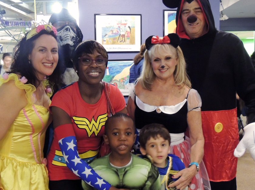 Children and adults posing for picture in Halloweeen costumes. 