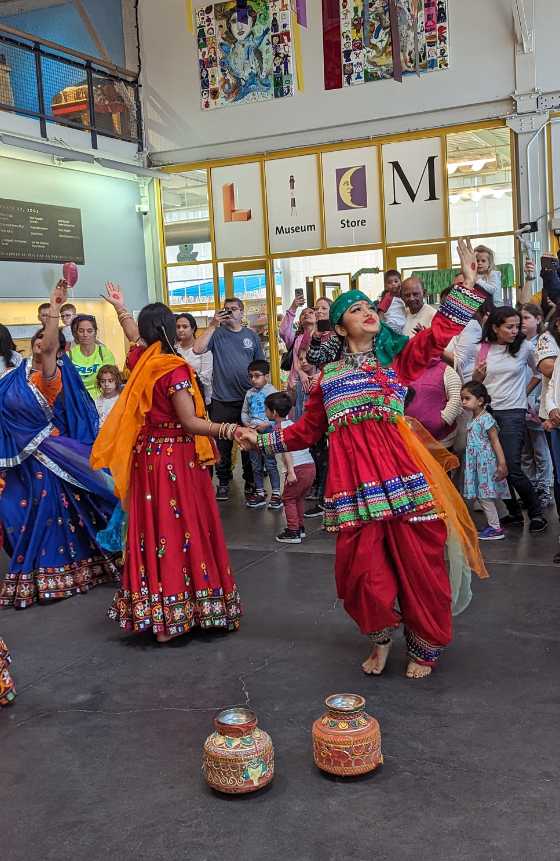 A group of dancers dressed in tradional clothing for a Holi celebration. 