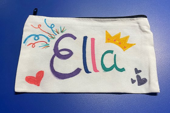 A canvas pencil case decorated and includes the text "Ella."