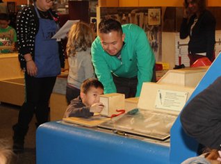 Photo of an adult and a child looking at an exhibit.