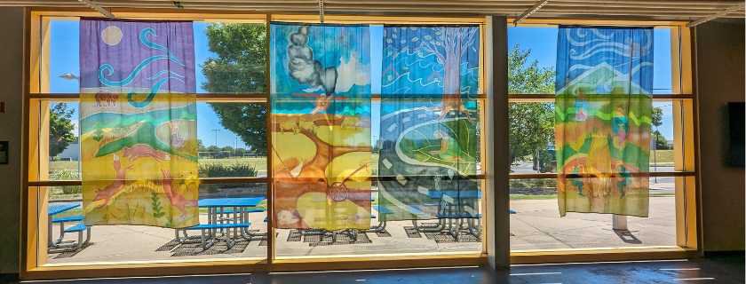 Four lage paintings on silks featuring nature landscapes hanging in LICM's outter lobby windows. 