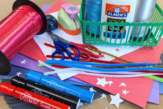 Red, white and blue ribbon, paper, markers, pipe cleaners, and star stampers. 