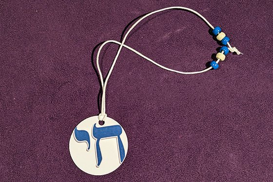 Necklace with blue and white "chai" symbol and blue and white beads.