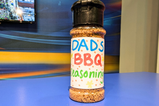 A plastic container filled with spices and a handmade sign that reads "Dad's BBQ Seasoning." 