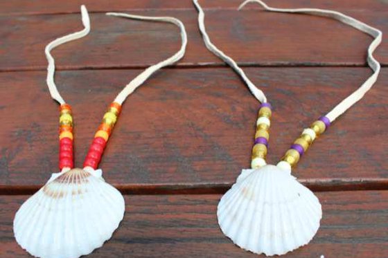 Two necklaces with leather string, a shell and beads. 